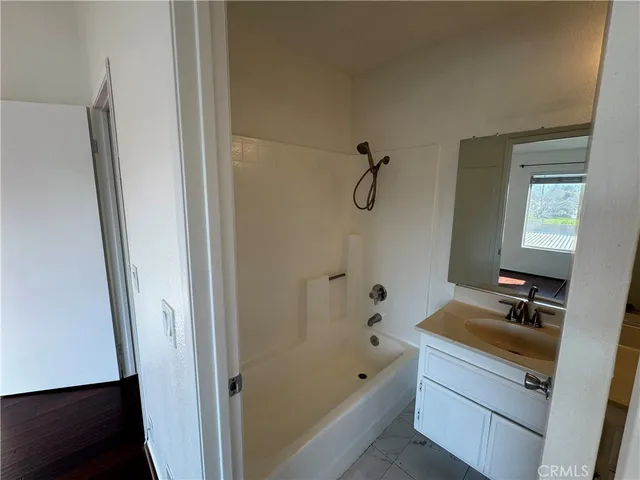 a bathroom with a tub a sink and a mirror