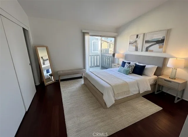 a bedroom with a bed and a large mirror on the dresser