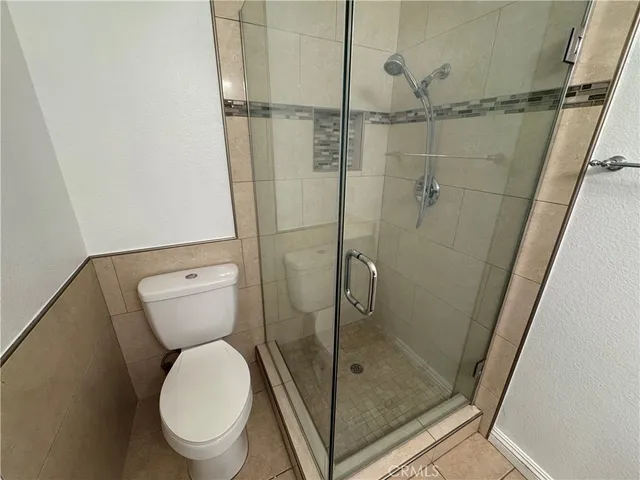 a bathroom with a granite countertop toilet and a shower