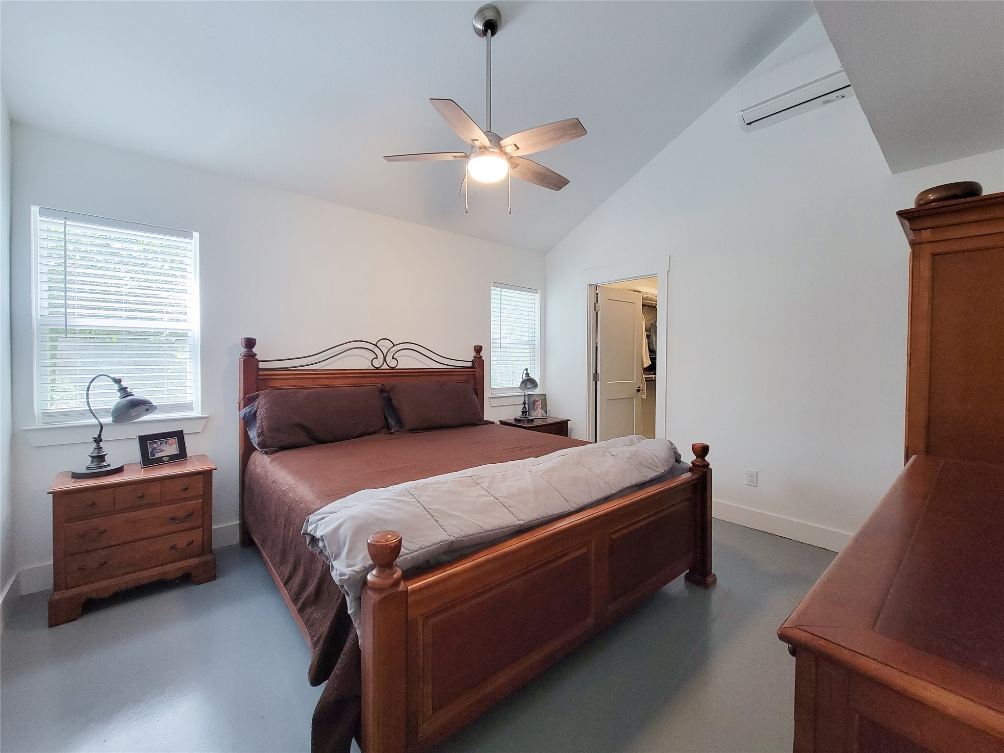 4937 Wolff Road Round Top, TX 78954 - Photo 15 of 31 Expansive downstairs bedroom with vaulted ceilings and sleek concrete floors.