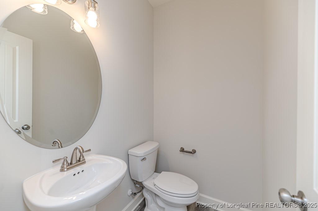 87 Onslow Court Spring Lake, NC 28390 - Photo 13 of 32 a bathroom with a toilet a sink and mirror
