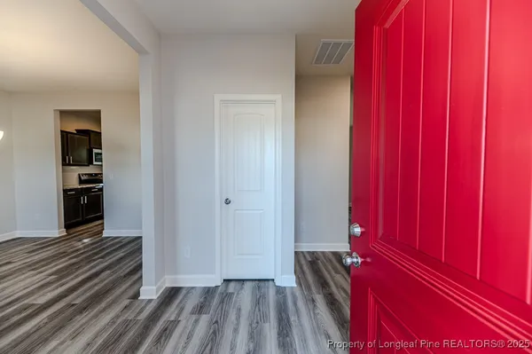 a view of a hallway with wooden floor and closet