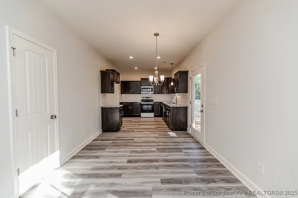 a large kitchen with kitchen island a stove a sink dishwasher and a refrigerator with wooden floor