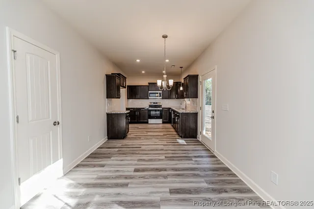 a large kitchen with kitchen island a stove a sink dishwasher and a refrigerator with wooden floor