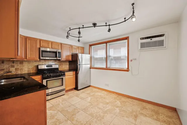 a kitchen with stainless steel appliances granite countertop a stove and a refrigerator