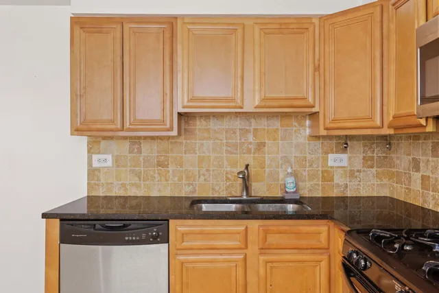 a kitchen with granite countertop a sink stainless steel appliances