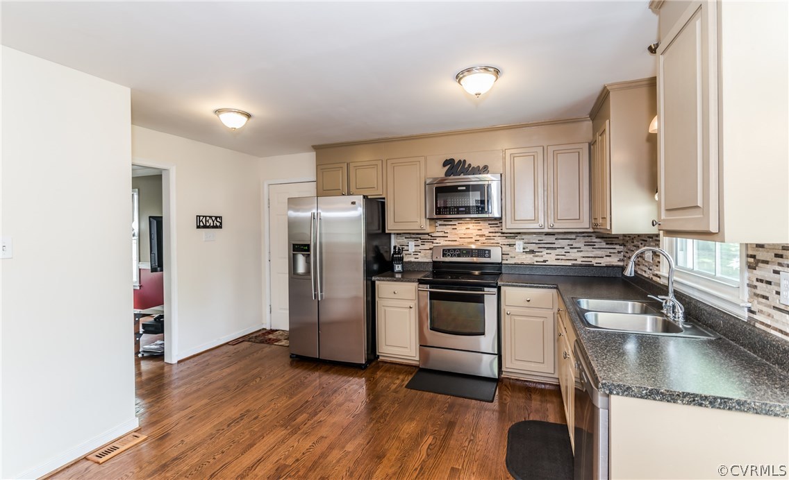4824 Cedar Cliff Road Chester, VA 23831 - Photo 26 of 50 a kitchen with a refrigerator a stove top oven a sink and dishwasher with wooden floor