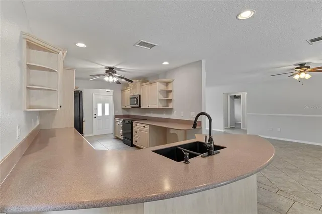 a kitchen with stainless steel appliances granite countertop a sink a stove and a refrigerator