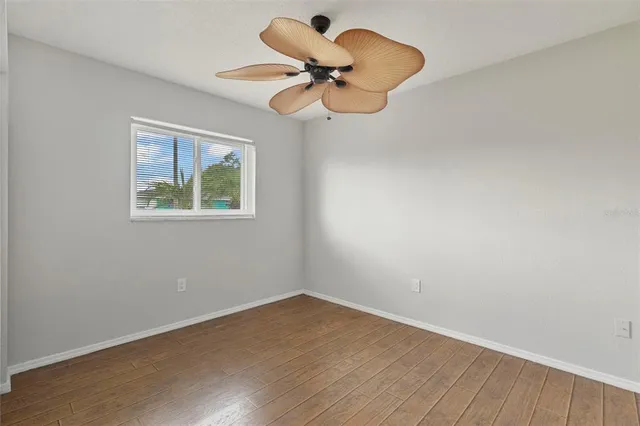 a view of room with wooden floor and ceiling fan