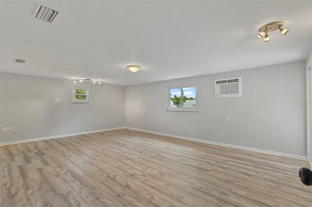 an empty room with a window and a ceiling fan