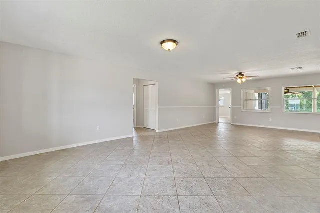 an empty room with windows and fireplace