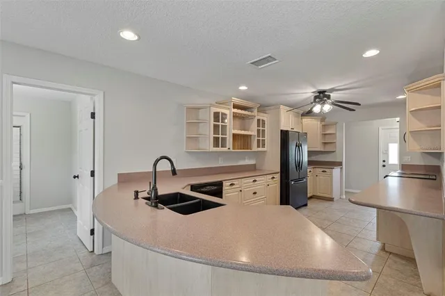 a kitchen with stainless steel appliances a sink a refrigerator and a stove with wooden floor