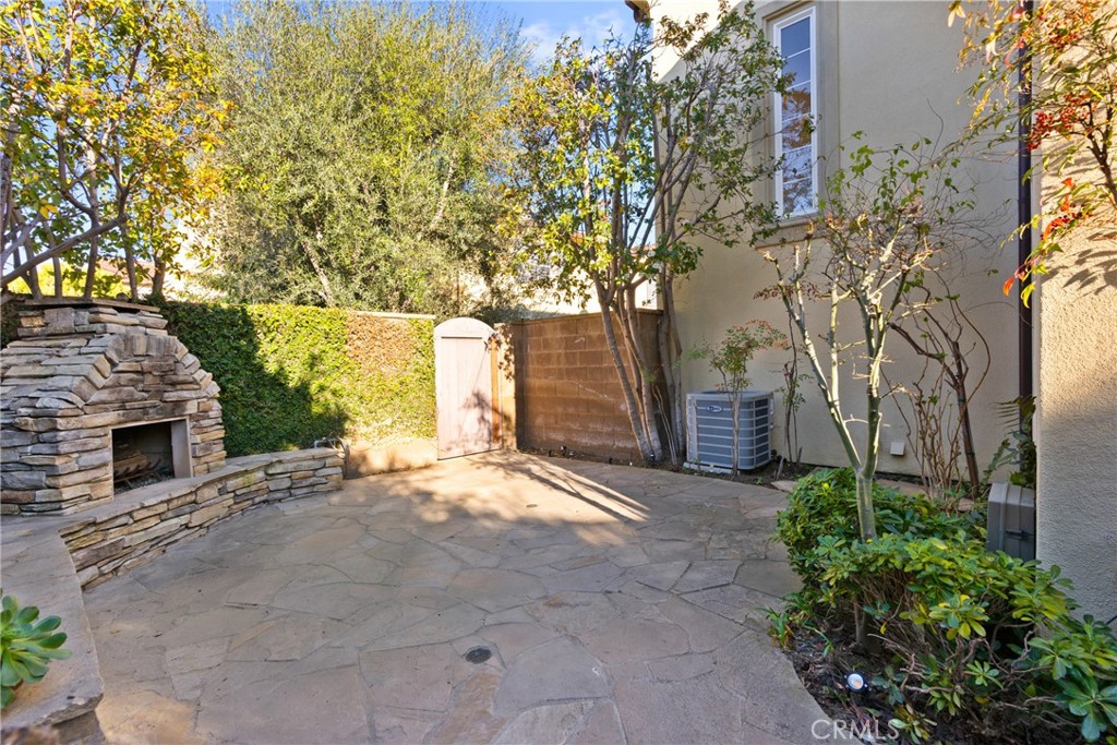 55 Bower Tree Irvine, CA 92603 - Photo 24 of 32 a backyard of a house with large trees and brick walls