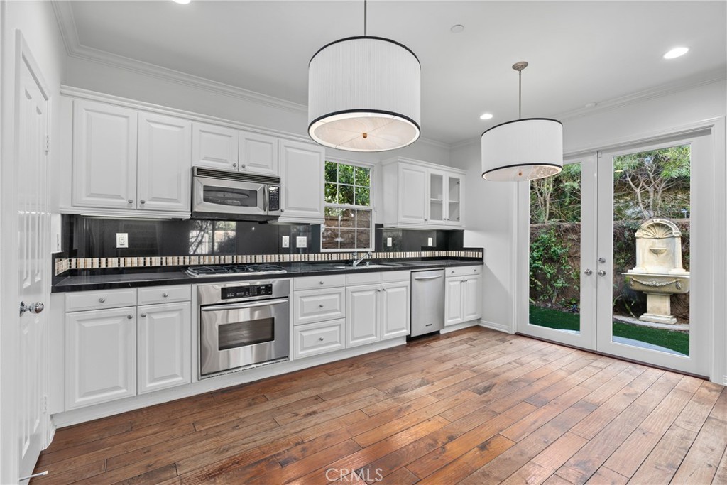 55 Bower Tree Irvine, CA 92603 - Photo 5 of 32 a kitchen with stainless steel appliances granite countertop a stove a sink and a microwave