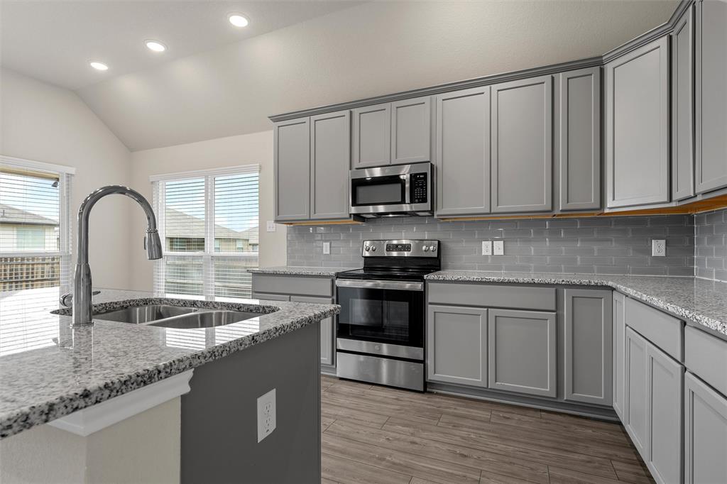 3208 Dottavio Road Lorena, TX 76655 - Photo 10 of 31 Kitchen featuring light gray cabinetry, stainless steel appliances, granite countertops, and a gray subway tile backsplash