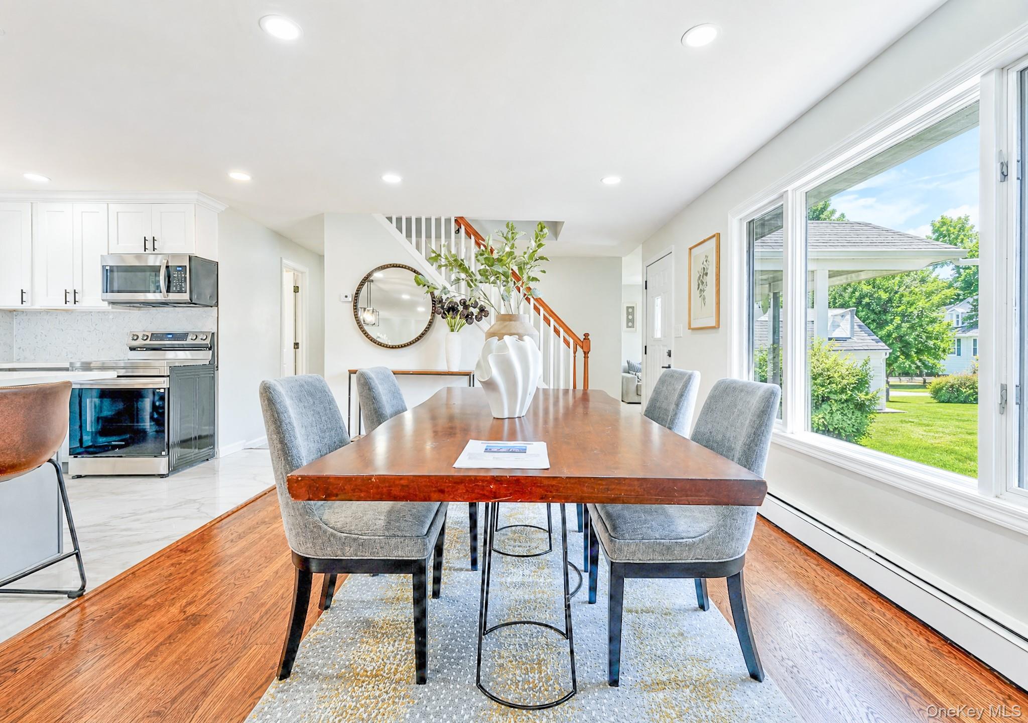 61 Cheshire Road Bethpage, NY 11714 - Photo 10 of 25 Spacious dining area featuring rich wood-finish flooring, abundant natural light from large windows, recessed lighting, and an open concept layout