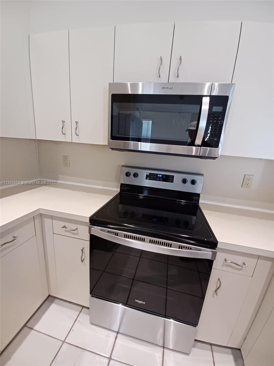 680 Falling Water Road Weston, FL 33326 - Photo 11 of 37 a kitchen with granite countertop a stove and a microwave