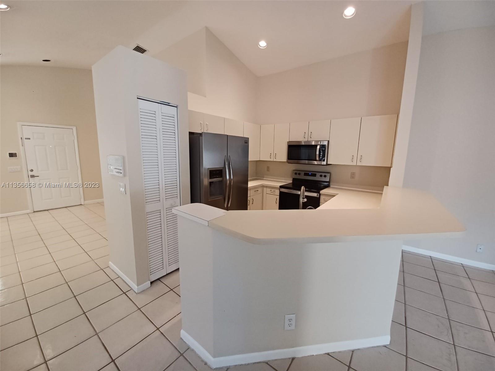 680 Falling Water Road Weston, FL 33326 - Photo 12 of 37 a kitchen with stainless steel appliances a refrigerator and a stove top oven