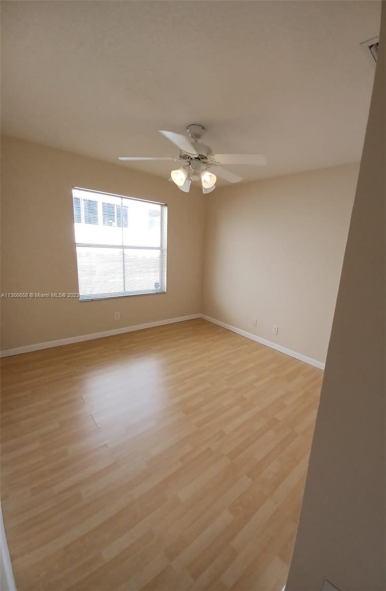 680 Falling Water Road Weston, FL 33326 - Photo 19 of 37 an empty room with wooden floor and windows