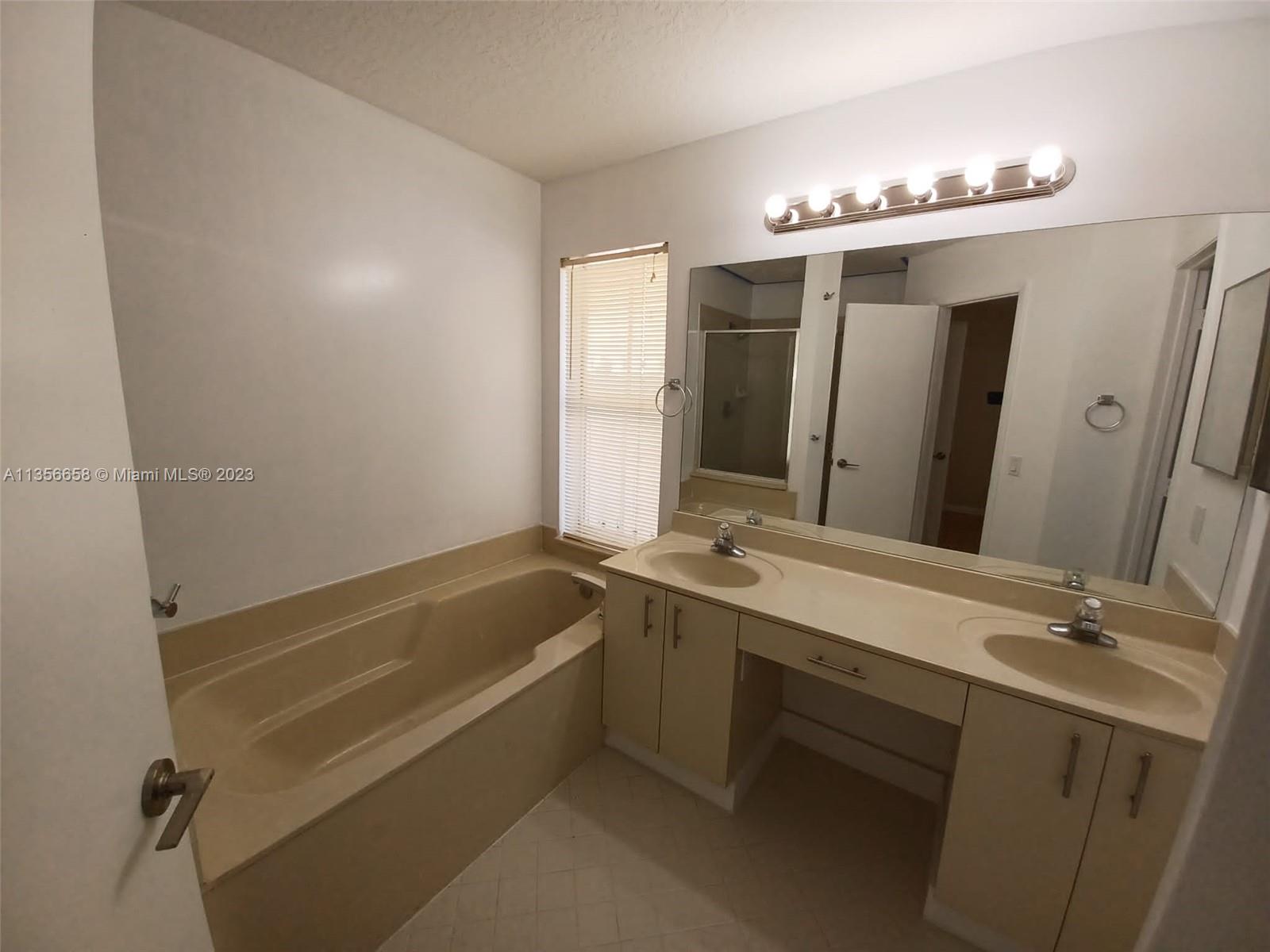 680 Falling Water Road Weston, FL 33326 - Photo 25 of 37 a bathroom with a tub sink and mirror