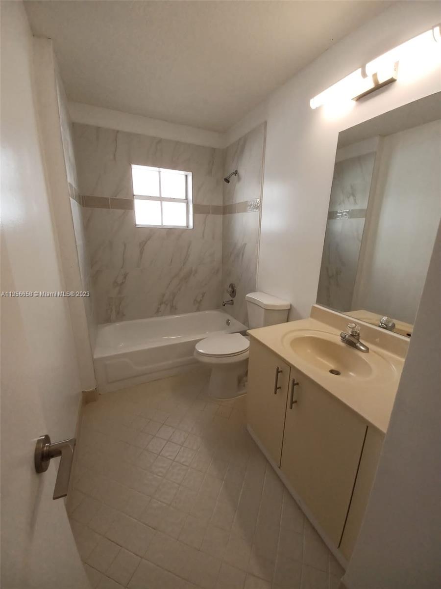 680 Falling Water Road Weston, FL 33326 - Photo 28 of 37 a bathroom with a granite countertop sink a toilet a mirror and bathtub