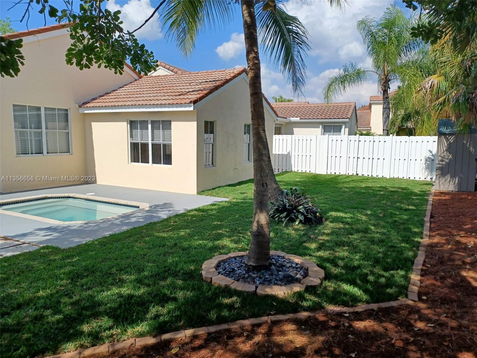 680 Falling Water Road Weston, FL 33326 - Photo 3 of 37 a front view of a house with a garden