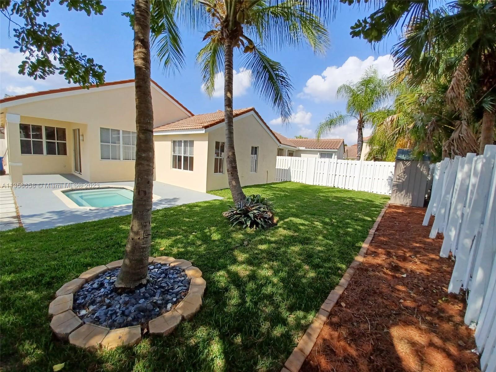 680 Falling Water Road Weston, FL 33326 - Photo 4 of 37 a view of a house with a small yard and palm trees