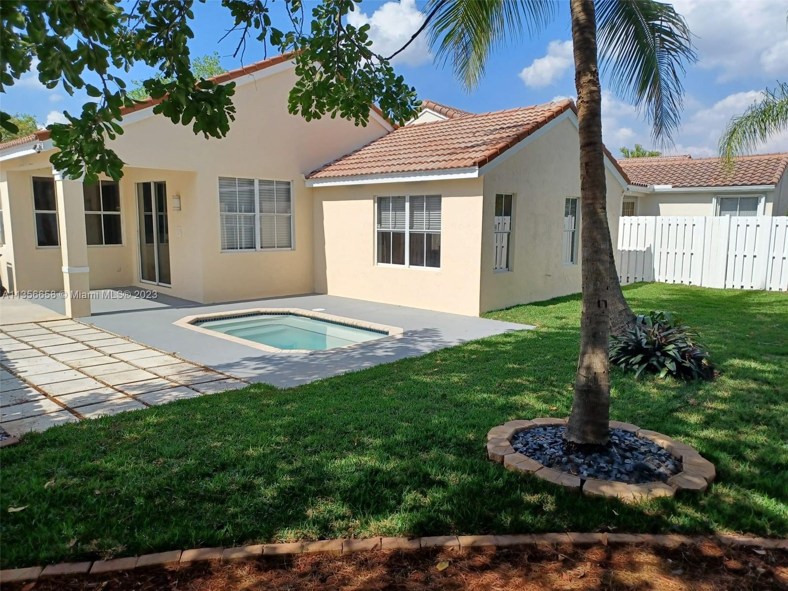 680 Falling Water Road Weston, FL 33326 - Photo 5 of 37 a front view of a house with a garden and yard