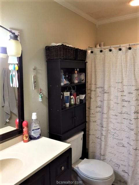 4400 Boyett Street, Unit B Bryan, TX 77801 - Photo 7 of 11 a bathroom with a sink vanity mirror and toilet