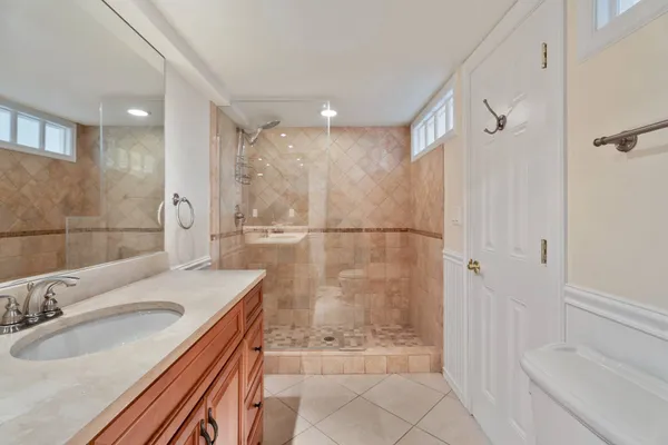 a bathroom with a sink a toilet and shower