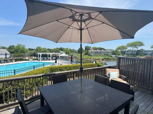 a view of a balcony with wooden floor and umbrella