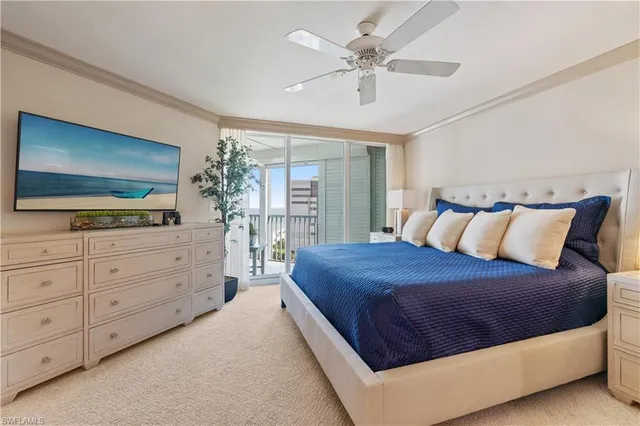 a bedroom with a large bed and a flat tv screen on dresser