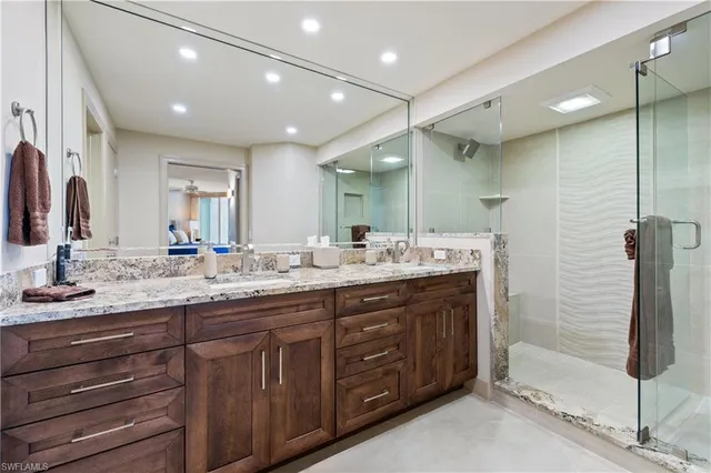 a bathroom with double vanity sinks and a shower