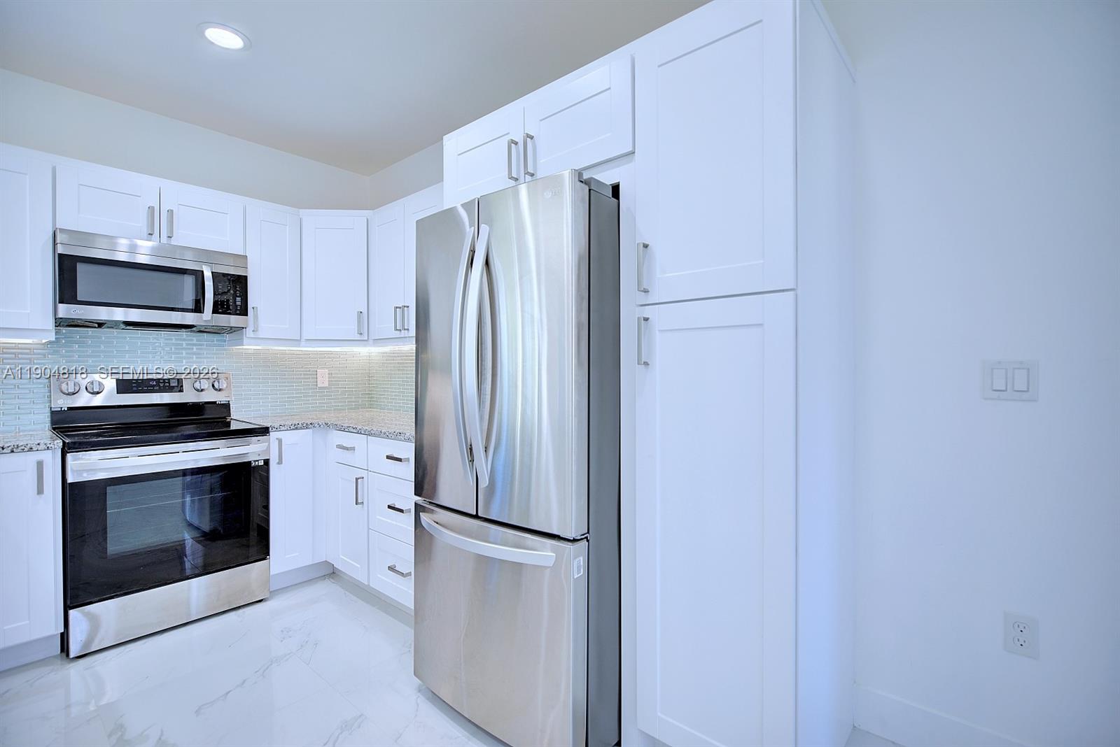 827 Renault Avenue Sebring, FL 33872 - Photo 11 of 27 a kitchen with stainless steel appliances a refrigerator and a stove top oven