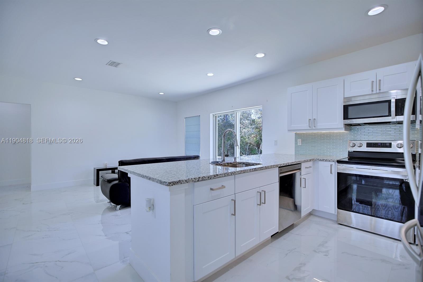 827 Renault Avenue Sebring, FL 33872 - Photo 12 of 27 a kitchen with granite countertop cabinets stainless steel appliances and a counter space