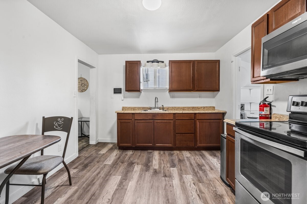 1916 Martin Luther King Junior Way Tacoma, WA 98405 - Photo 9 of 17 a kitchen with stainless steel appliances kitchen island granite countertop a sink stove and microwave