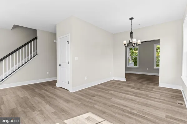 a view of empty room with wooden floor and window