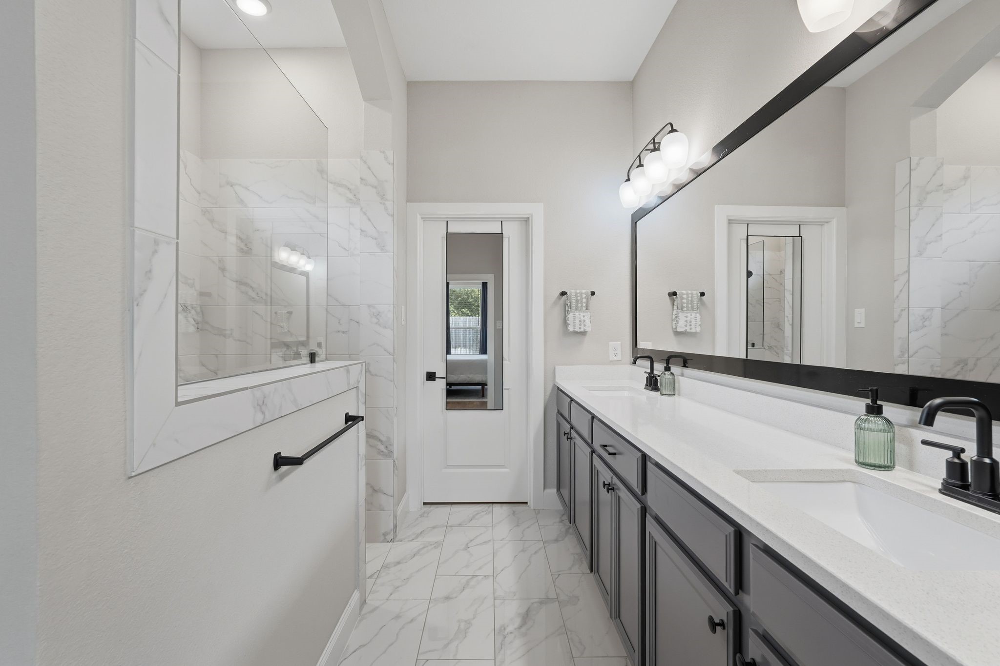24423 Morningside Terrace Tomball, TX 77375 - Photo 7 of 47 a bathroom with a double vanity sink a mirror and a shower