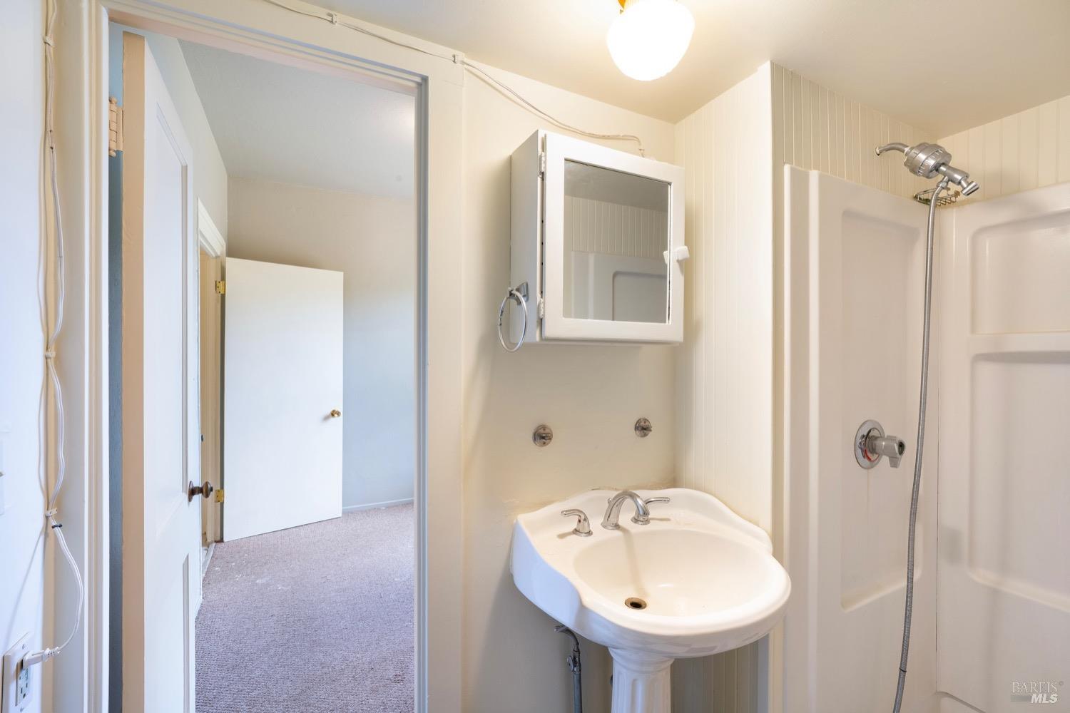 1664 Spring Street St. Helena, CA 94574 - Photo 17 of 27 a bathroom with a sink mirror and shower