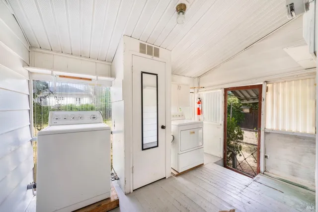 a view of backyard with large tree and wooden fence