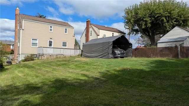 a view of backyard with a small cabin and a chair