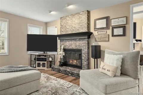 a living room with furniture a flat screen tv and a fireplace