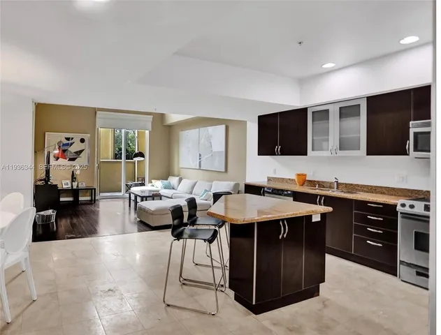 a living room with furniture a flat screen tv and kitchen view
