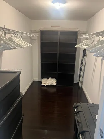 a view of walk in closet with clothes and shoes