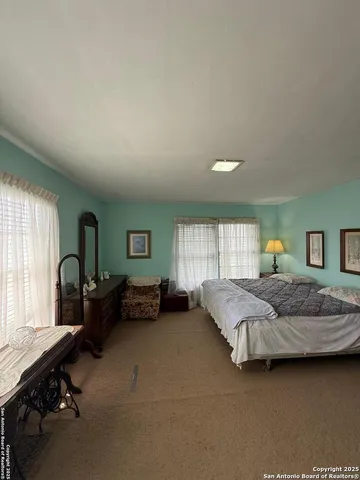 a bedroom with a bed couch and a window