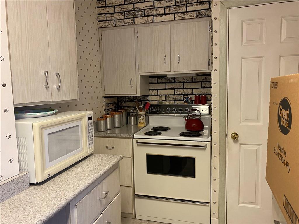 2300 Cottage Avenue Natrona Heights, PA 15065 - Photo 6 of 15 a kitchen with white cabinets and white appliances