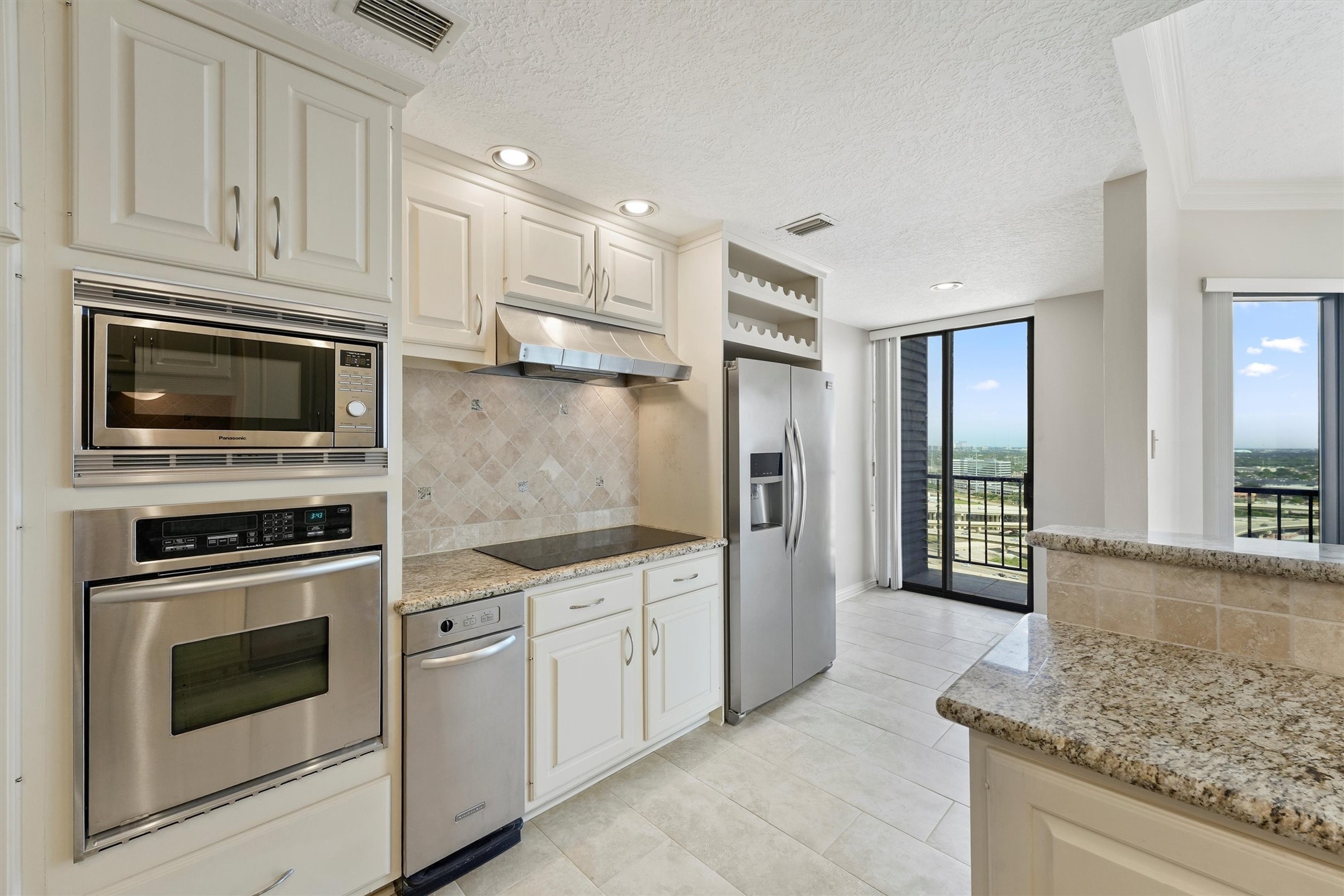 3350 McCue Road, Unit 2301 Houston, TX 77056 - Photo 11 of 31 a kitchen with granite countertop white cabinets stainless steel appliances and a counter space