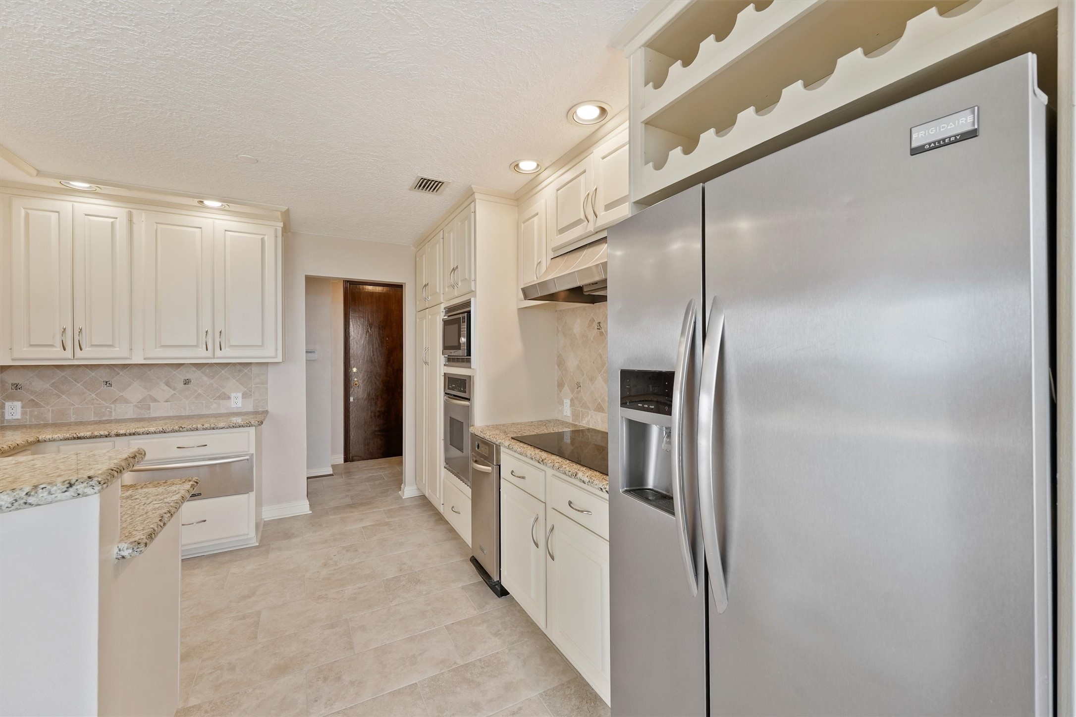 3350 McCue Road, Unit 2301 Houston, TX 77056 - Photo 12 of 31 a large white kitchen with cabinets and stainless steel appliances