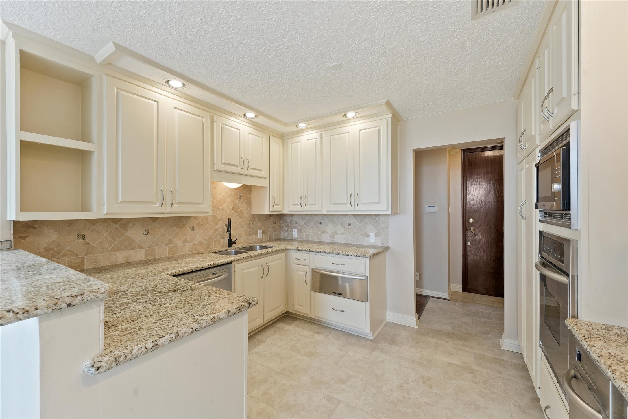 3350 McCue Road, Unit 2301 Houston, TX 77056 - Photo 10 of 31 a kitchen with granite countertop cabinets stainless steel appliances and a counter space