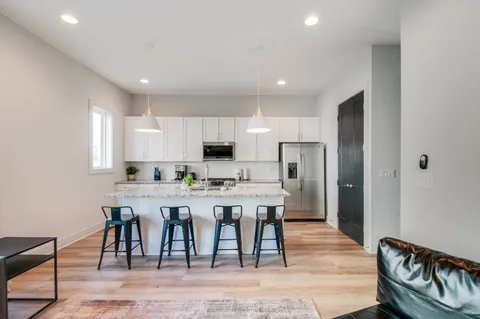 a kitchen with a table chairs refrigerator and microwave